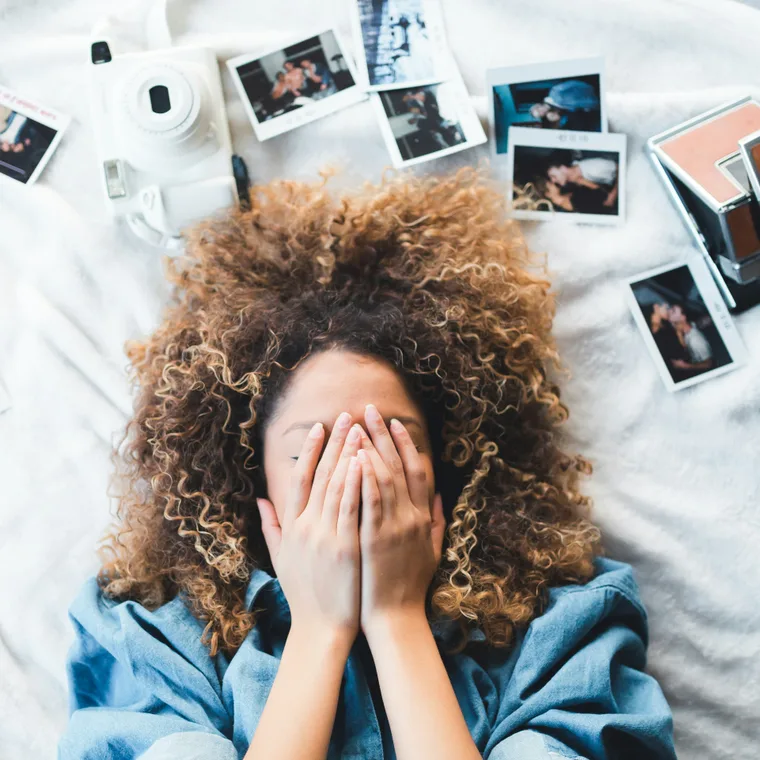 Lying among scattered polaroids